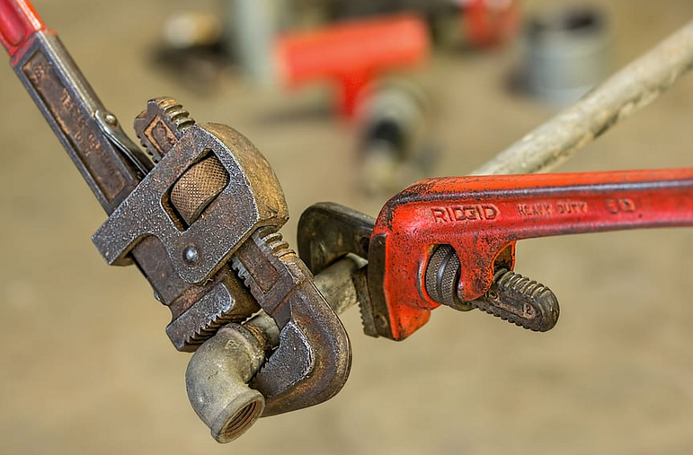 two wrenches on a pipe